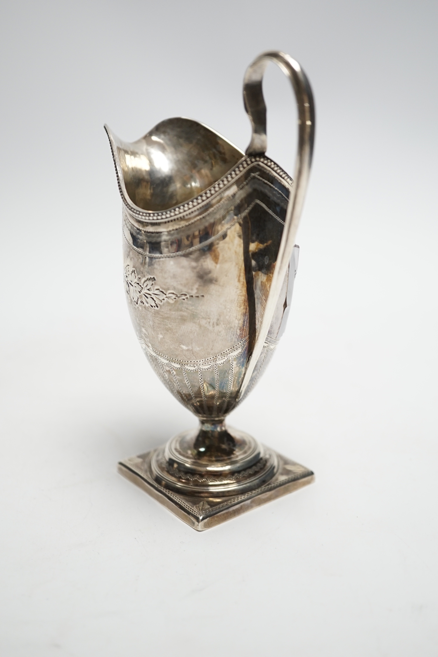 A George III engraved silver helmet shaped cream jug, on square foot, Soloman Hougham, London, 1796, 15cm, 3.6oz.